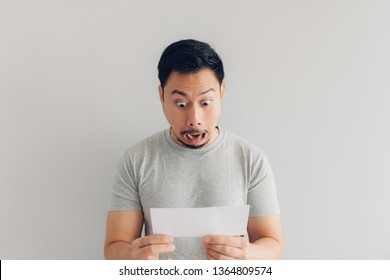 Asian man is shocked and surprised with the white mail message or the bill.