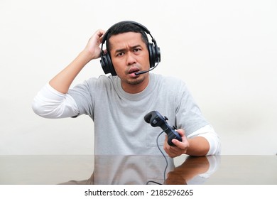 Asian Man Showing Confused Expression When Playing Game