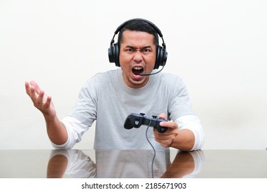 Asian man showing rage expression when playing game - Shutterstock ID 2185671903