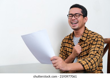 Asian Man Showing Relieved Expression While Holding A Letter