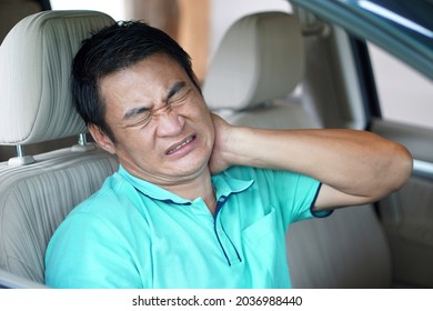 Asian man sits in car and feels hurt his neck because of long distance driving. Concept : Injury, pain or tired from driving. Unsafe driving during abnormal symptoms. Transport and healthcare. 