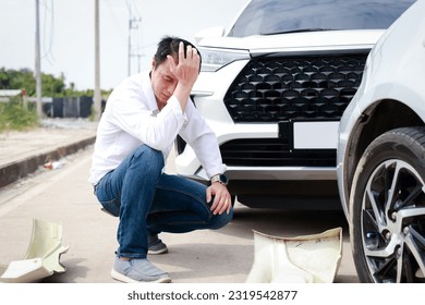 Asian man sits stressed out after a car crash on the road. The concept of traffic accidents and insurance. - Powered by Shutterstock