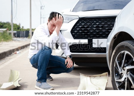 Asian man sits stressed out after a car crash on the road. The concept of traffic accidents and insurance.