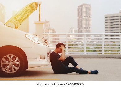 Asian Man Sitting Front A Broken Car Calling For Assistance. A Man Calling For Assistance With His Car Broken Down By The Parking Lot. Insurance, Car Service