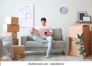 Asian Man Sitting On Sofa After Moving To New House