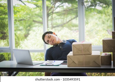 Asian Man Sleep Because Of Woking Hard With Laptop And Postal Parcel Box On White Desk, Selling Online Concept 