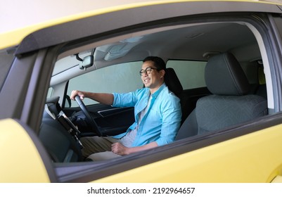 Asian Man Smiling Happy While Driving His Car