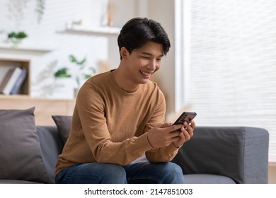 Asian man is smiling on the cellphone like he got a good news. The man seems so happy with the mobile phone screen. Technology make us have a convenience life and also make the world getting smaller. - Shutterstock ID 2147851003