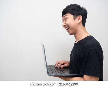 Asian Man Smiling And Using Laptop Side View