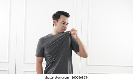 Asian Man Sniffing His Shirt