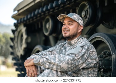 Asian man special forces soldier against on the field Mission. Commander Army soldier military defender of the nation in uniform sitting near battle tank while state of war. - Powered by Shutterstock