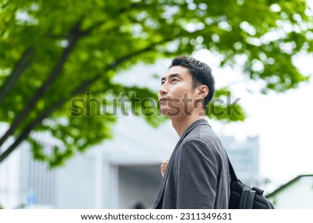 Asian man standing in the street.
