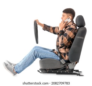 Asian Man With Steering Wheel And Mobile Phone Sitting On Car Seat Against White Background