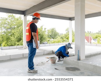 Asian man structural engineer foreman wearing safety gear hard hat high visibility vest checking examine labor workers inspecting progressing work in construction site or building development concept. - Powered by Shutterstock