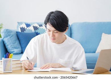 Asian man studying at home - Shutterstock ID 2065420667