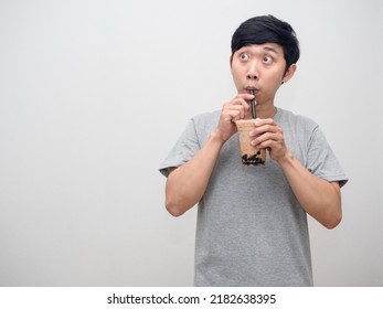 Asian man sucking boba tea and looking at copy space