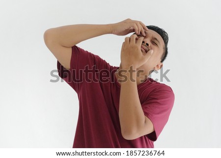 asian man suffering eye problems, hands scratching eye, isolated in white