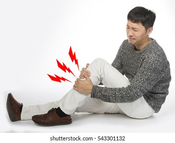 Asian Man Suffering From Shin Pain, Sits On The White Floor