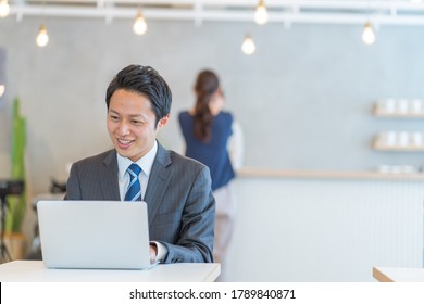 Asian man in a suit working indoors