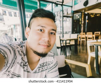 Asian Man Is Taking Selfie In Restuarant.