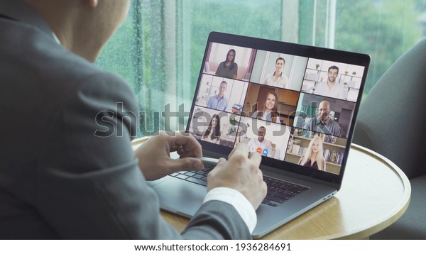 Asian man talking to multi ethnic group of business\
people working from home and office, talking to colleagues in\
webcam group video call conference technology on screen online in\
quarantine. Team
