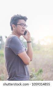 Asian Man Talking On A Phone Outdoor