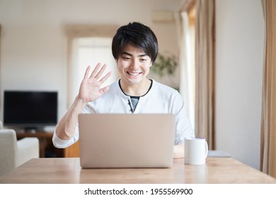 Asian Man Talking Online With A Smile