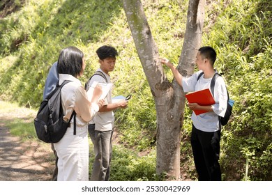 Asian Man Team Leader Or Teacher Is Teaching Botanical Tree With High School Students. Outdoor Classroom. - Powered by Shutterstock