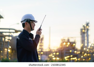 Asian man technician Industrial engineer using walkie-talkie and holding bluprint working in oil refinery for building site survey in civil engineering project.