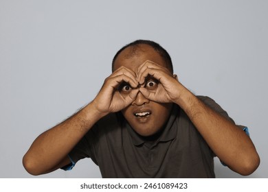 Asian man telescopes with both hands                               - Powered by Shutterstock