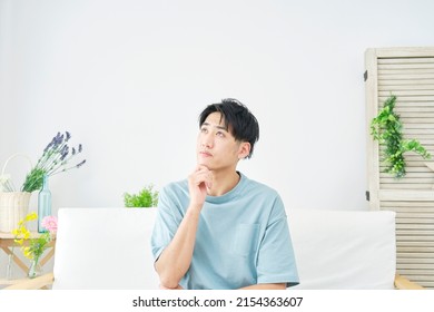 Asian Man Thinking At Home