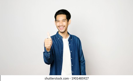 Asian Man Thumb Up And Smile While Standing Isolated On Grey Background, Happy Asia Guy Showing Good, Great Gesture Sign, Positive Expression 