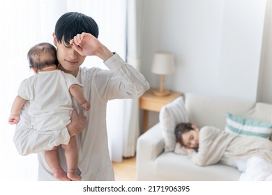 Asian Man Tired Of Rearing A Baby. Exhausted With Parenting.