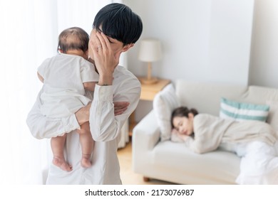 Asian Man Tired Of Rearing A Baby. Exhausted With Parenting.