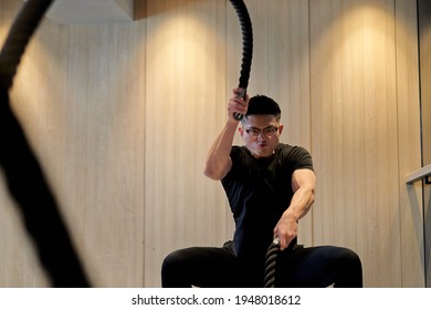 Asian Man Training On A Battle Rope