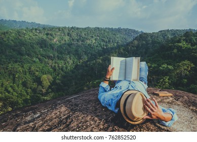 Asian man travel relax in the holiday. sleep relax read books on rocky cliffs. On the Moutain. In Thailand - Powered by Shutterstock