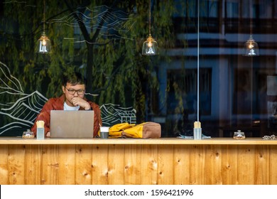 Asian Man Traveller Using Laptop In The Coffee Cafe