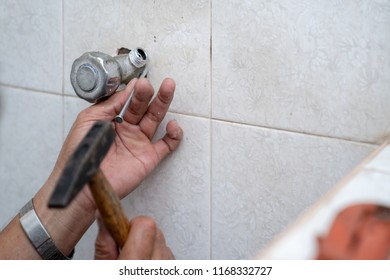 Asian man tries to fix and repair pipe / shower in the old restroom.