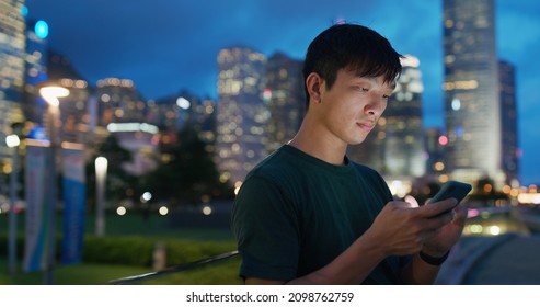 Asian man use of cellphone at night
