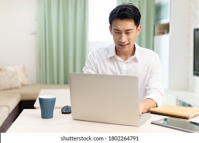 Asian Man Use Laptop To Work In The Living Room At Home