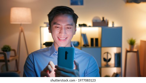 Asian Man Use Smart Phone And Watches Something Interesting On Social Media Happily At Home In The Evening