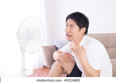 Asian Man Uses The Electric Fan