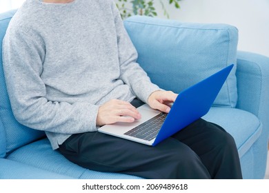 Asian Man Using The Laptop On The Sofa, No Face