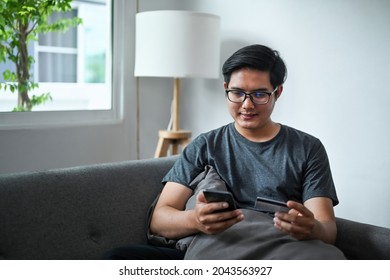 Asian Man Using Smart Phone And Holding Credit Card For Baking On Line Or Shopping On Line.