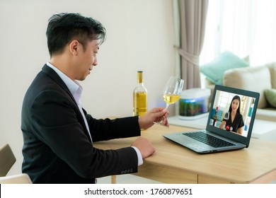 Asian Man Virtual Happy Hour Meeting Party And Drinking White Grape Wine Online Together With His Friend In Video Conference With Digital Tablet For A Online Meeting In Video Call 