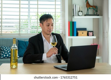 Asian Man Virtual Happy Hour Meeting Party And Drinking White Grape Wine Online Together With His Friend In Video Conference With Digital Tablet For A Online Meeting In Video Call