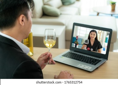 Asian Man Virtual Happy Hour Meeting Party And Drinking White Grape Wine Online Together With His Friend In Video Conference With Digital Tablet For A Online Meeting In Video Call 