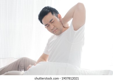 Asian Man Wake Up And Stretching In Bed.