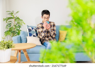 Asian Man Warming Up With A Cup