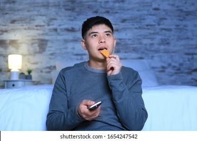 Asian Man Watching TV At Home In Evening